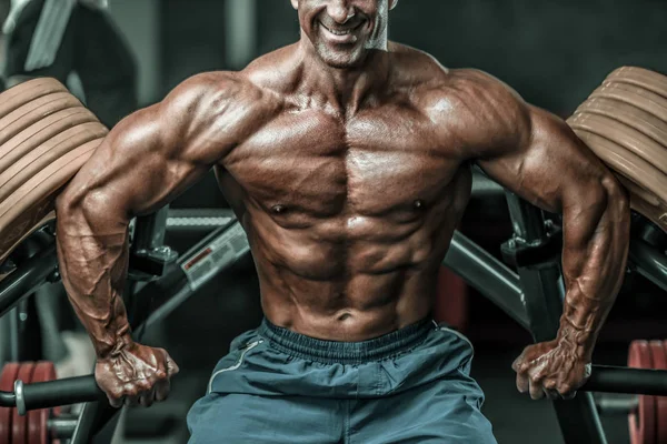 Acımasız güçlü vücut geliştirmeci atletik kasları egzersiz vücut geliştirme kavramı arka plan - kas vücut geliştirmeci yakışıklı erkekler spor salonu çıplak gövde kavramı spor ve diyet egzersiz yapıyor pompalama adam yaşlı