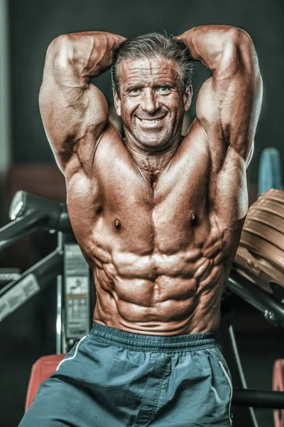 Acımasız güçlü vücut geliştirmeci atletik kasları egzersiz vücut geliştirme kavramı arka plan - kas vücut geliştirmeci yakışıklı erkekler spor salonu çıplak gövde kavramı spor ve diyet egzersiz yapıyor pompalama adam yaşlı