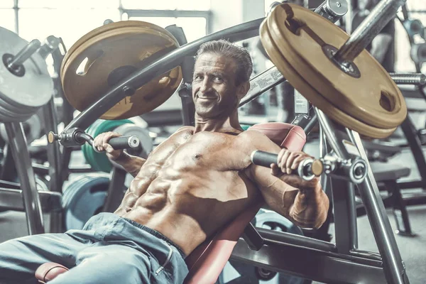 Acımasız güçlü vücut geliştirmeci atletik kasları egzersiz vücut geliştirme kavramı arka plan - kas vücut geliştirmeci yakışıklı erkekler spor salonu çıplak gövde kavramı spor ve diyet egzersiz yapıyor pompalama adam yaşlı