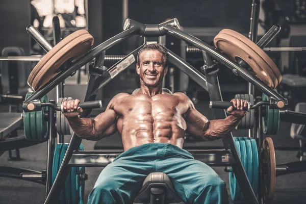 Acımasız güçlü vücut geliştirmeci atletik kasları egzersiz vücut geliştirme kavramı arka plan - kas vücut geliştirmeci yakışıklı erkekler spor salonu çıplak gövde kavramı spor ve diyet egzersiz yapıyor pompalama adam yaşlı