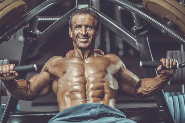 Acımasız güçlü vücut geliştirmeci atletik kasları egzersiz vücut geliştirme kavramı arka plan - kas vücut geliştirmeci yakışıklı erkekler spor salonu çıplak gövde kavramı spor ve diyet egzersiz yapıyor pompalama adam yaşlı