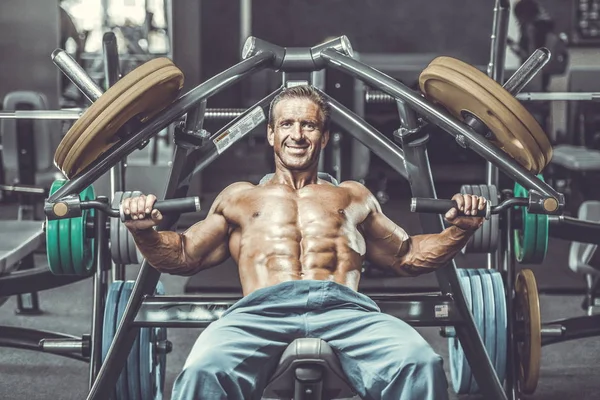 Acımasız güçlü vücut geliştirmeci atletik kasları egzersiz vücut geliştirme kavramı arka plan - kas vücut geliştirmeci yakışıklı erkekler spor salonu çıplak gövde kavramı spor ve diyet egzersiz yapıyor pompalama adam yaşlı