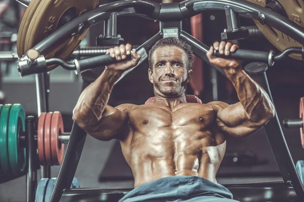 Acımasız güçlü vücut geliştirmeci atletik kasları egzersiz vücut geliştirme kavramı arka plan - kas vücut geliştirmeci yakışıklı erkekler spor salonu çıplak gövde kavramı spor ve diyet egzersiz yapıyor pompalama adam yaşlı