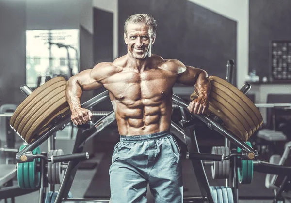 Acımasız güçlü vücut geliştirmeci atletik kasları egzersiz vücut geliştirme kavramı arka plan - kas vücut geliştirmeci yakışıklı erkekler spor salonu çıplak gövde kavramı spor ve diyet egzersiz yapıyor pompalama adam yaşlı