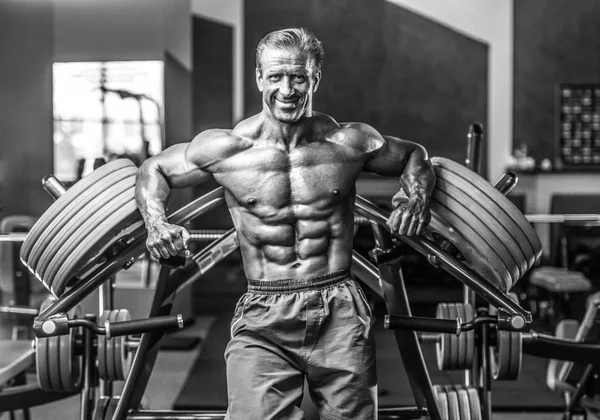 Acımasız güçlü vücut geliştirmeci atletik kasları egzersiz vücut geliştirme kavramı arka plan - kas vücut geliştirmeci yakışıklı erkekler spor salonu çıplak gövde kavramı spor ve diyet egzersiz yapıyor pompalama adam yaşlı