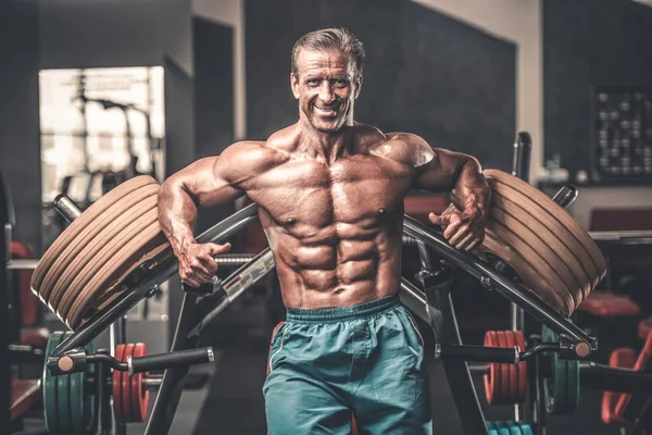 Acımasız güçlü vücut geliştirmeci atletik kasları egzersiz vücut geliştirme kavramı arka plan - kas vücut geliştirmeci yakışıklı erkekler spor salonu çıplak gövde kavramı spor ve diyet egzersiz yapıyor pompalama adam yaşlı