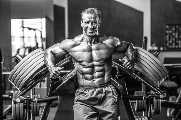 Acımasız güçlü vücut geliştirmeci atletik kasları egzersiz vücut geliştirme kavramı arka plan - kas vücut geliştirmeci yakışıklı erkekler spor salonu çıplak gövde kavramı spor ve diyet egzersiz yapıyor pompalama adam yaşlı