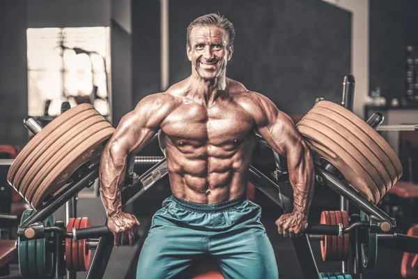 Acımasız güçlü vücut geliştirmeci atletik kasları egzersiz vücut geliştirme kavramı arka plan - kas vücut geliştirmeci yakışıklı erkekler spor salonu çıplak gövde kavramı spor ve diyet egzersiz yapıyor pompalama adam yaşlı