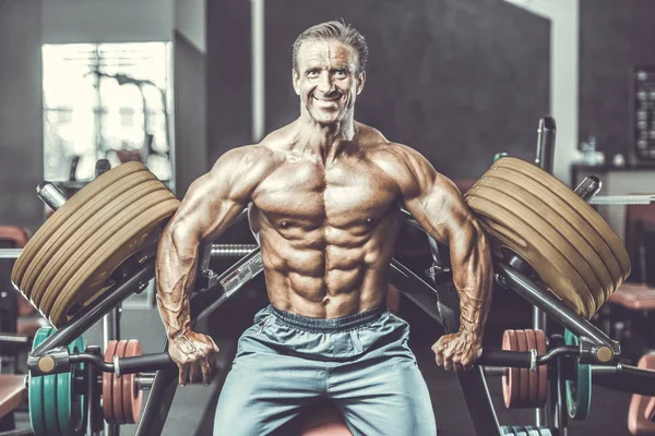 Acımasız güçlü vücut geliştirmeci atletik kasları egzersiz vücut geliştirme kavramı arka plan - kas vücut geliştirmeci yakışıklı erkekler spor salonu çıplak gövde kavramı spor ve diyet egzersiz yapıyor pompalama adam yaşlı