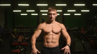 Yakışıklı atletik erkekler kaslarını şişiriyor, spor yapıyor, vücut geliştirme egzersizleri yapıyor, vücut geliştirme konsepti uyguluyor, kaslı vücut geliştiriciler spor salonunda çıplak vücut egzersizleri yapıyor.