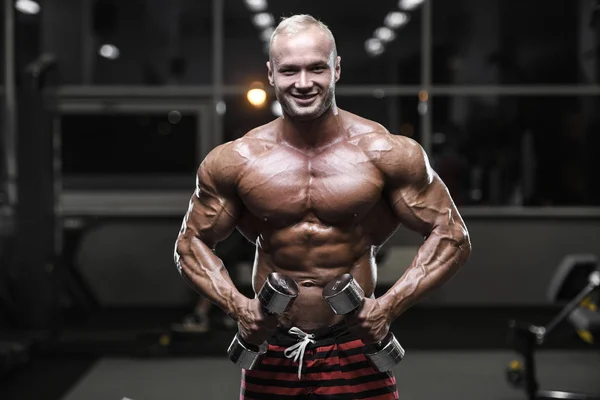 Stilig stark bodybuilder atletiska män pumpa upp muskler med — Stockfoto