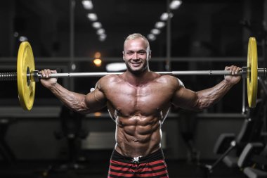 yakışıklı güçlü vücut geliştirmeci atletik erkek ile kasları kadar pompalama