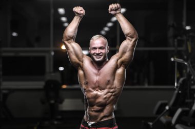 yakışıklı güçlü vücut geliştirmeci atletik erkek ile kasları kadar pompalama