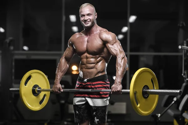 Beau bodybuilder fort hommes sportifs pompage les muscles avec — Photo