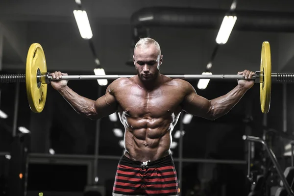 Beau bodybuilder fort hommes sportifs pompage les muscles avec — Photo