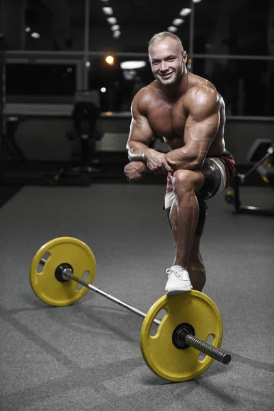 Handsome strong bodybuilder athletic men pumping up muscles with