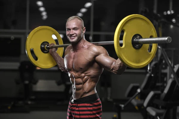Handsome strong bodybuilder athletic men pumping up muscles with — Stock Photo, Image