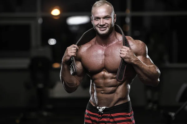 Stilig stark bodybuilder atletiska män pumpa upp muskler med — Stockfoto