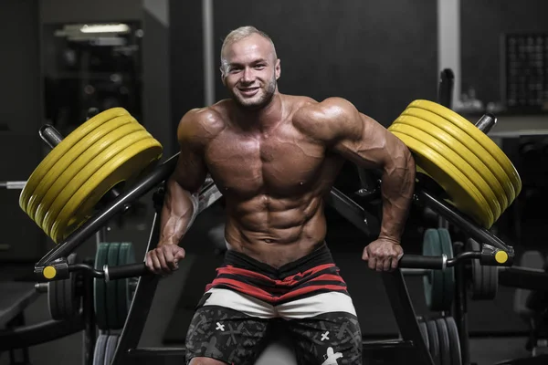 Stilig stark bodybuilder atletiska män pumpa upp muskler med — Stockfoto