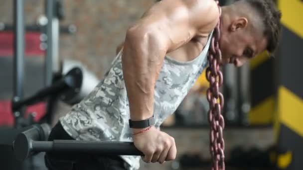 筋肉のトレーニングフィットネスとボディビルディングのコンセプトの背景を汲み上げるハンサムな強い運動能力の男性 筋肉のボディービルダーフィットネス男性はジムの裸の胴で腕のAbsバック演習を行う — ストック動画