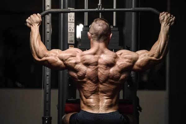 Hombres atléticos fuertes bombeando los músculos de la espalda entrenamiento fitness — Foto de Stock