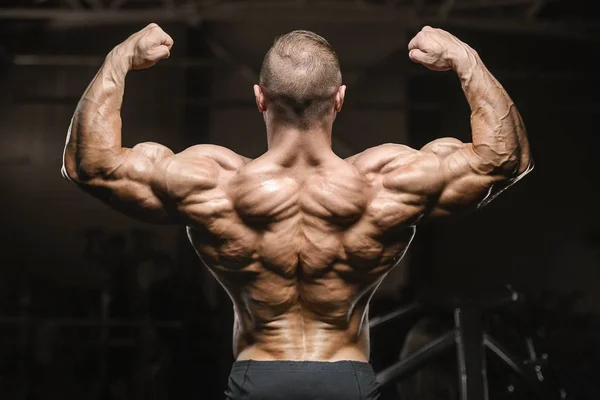 Starke athletische Männer, die die Rückenmuskulatur aufpumpen Fitness — Stockfoto