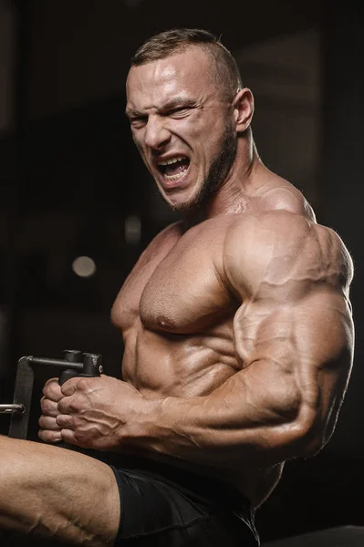 Musculoso fisiculturista homens fitness fazendo exercícios de armas no ginásio — Fotografia de Stock