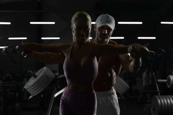 Homem atlético caucasiano e mulher bombeamento até músculos treino fitn — Fotografia de Stock