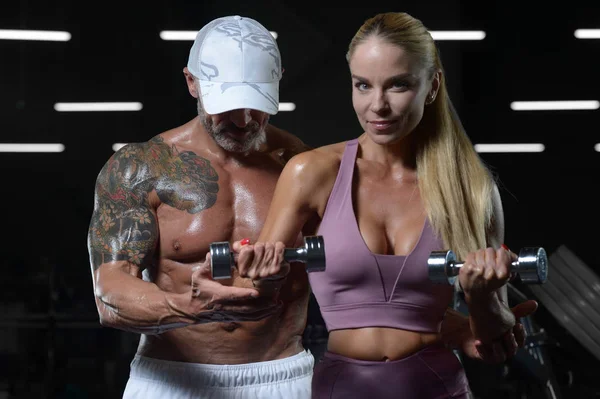 Caucásico atlético hombre y mujer bombeo hasta los músculos entrenamiento fitn — Foto de Stock