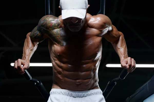 Przystojni sportowcy pompujący mięśnie pompkami na nierównych prętach — Zdjęcie stockowe