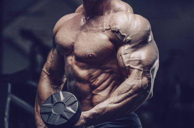 Vahşi güçlü atletik erkek kasları kas geliştiriyor.