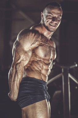 Vahşi güçlü atletik erkek kasları kas geliştiriyor.
