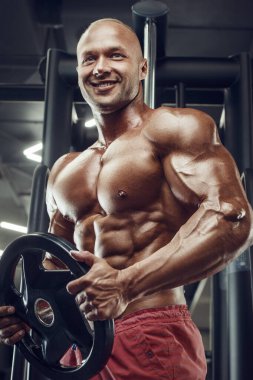 Vücut geliştiren yakışıklı, güçlü, atletik, kas geliştiren, spor yapan, vücut geliştiren, sağlıklı bir konsept geçmişi olan, spor salonunda çıplak bedende kol egzersizi yapan, kaslı, formda adamlar.