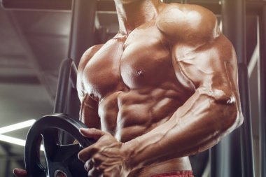 Vücut geliştiren yakışıklı, güçlü, atletik, kas geliştiren, spor yapan, vücut geliştiren, sağlıklı bir konsept geçmişi olan, spor salonunda çıplak bedende kol egzersizi yapan, kaslı, formda adamlar.