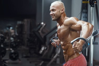 Vücut geliştiren yakışıklı, güçlü, atletik, kas geliştiren, spor yapan, vücut geliştiren, sağlıklı bir konsept geçmişi olan, spor salonunda çıplak bedende kol egzersizi yapan, kaslı, formda adamlar.
