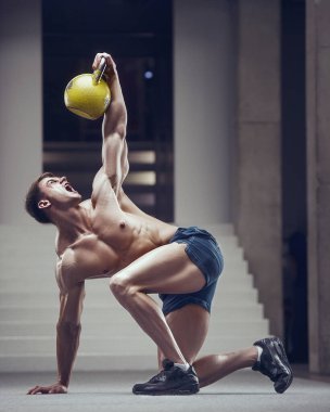 Vücut geliştirici yakışıklı güçlü atletik sert adam kaslarını kettlebell egzersizi ve vücut geliştirme sağlıklı konsept tasarımı ile pompalıyor - kaslı fitness erkekler beden eğitiminde göğüs egzersizi yapıyor