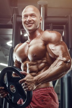 Vücut geliştiren yakışıklı, güçlü, atletik, kas geliştiren, spor yapan, vücut geliştiren, sağlıklı bir konsept geçmişi olan, spor salonunda çıplak bedende kol egzersizi yapan, kaslı, formda adamlar.