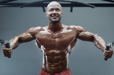 Vücut geliştiren yakışıklı, güçlü, atletik, kas geliştiren, spor yapan, vücut geliştiren, sağlıklı bir konsept geçmişi olan, spor salonunda çıplak bedende kol egzersizi yapan, kaslı, formda adamlar.