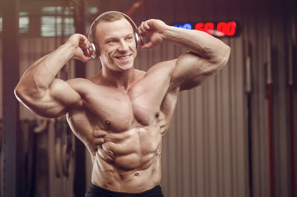 Fitnessman Met Hoofdtelefoon Tijdens Training Sportschool Bodybuilding Gezonde Concept Achtergrond — Stockfoto