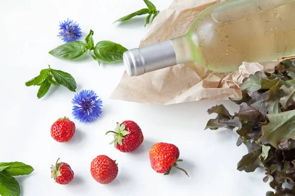 beyaz şarap ve gözlük, mavi çiçekler, çilek ve beyaz bir yaz arka plan üzerinde tatlı kiraz şişesi 