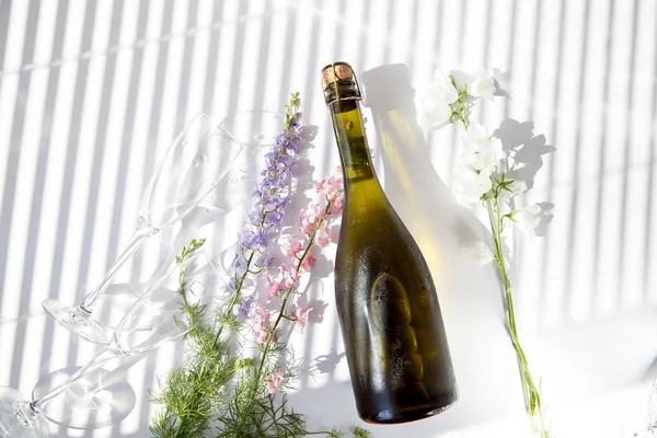 soğuk şampanya çiçek bardak güneşlikler aracılığıyla ışık beyaz bir arka plan üzerinde yatıyor