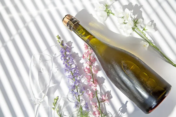 soğuk şampanya kör ler aracılığıyla çiçek ve ışık arka plan karşı masada