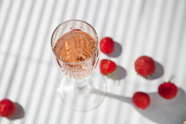 beyaz bir arka plan üzerinde çilek ile şampanya bir bardak