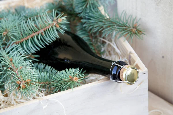 köpüklü şarap bir şişe Noel t ile ahşap bir kutu yatıyor