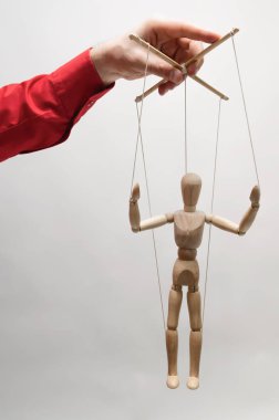 Concept of control. Marionette in woman's hand. clipart