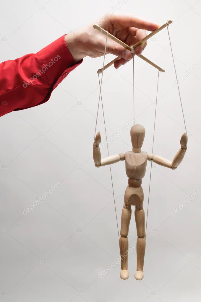 Concept of control. Marionette in woman's hand.