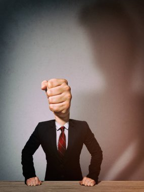 Elbiseli adam yumruk şeklinde bir kafa ile. Kızgın bir patron metaforu.