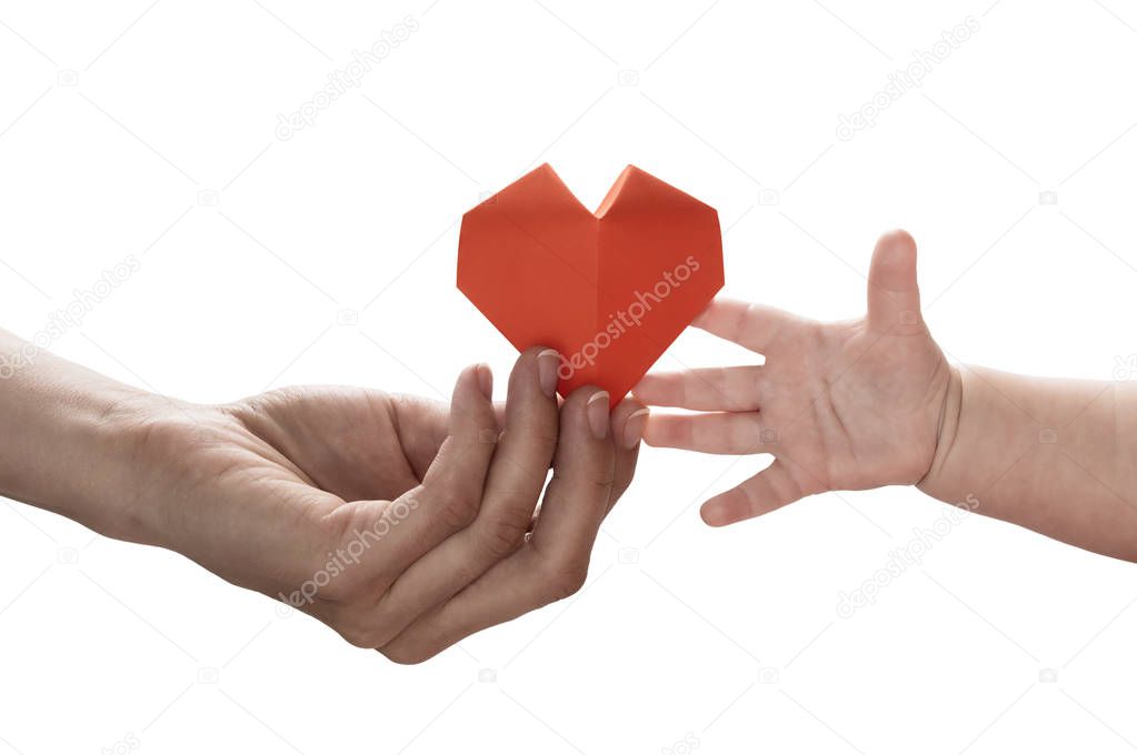 Baby to takes red paper heart from mom's hands. Concept of love, care, adoption. Color, isolated image.