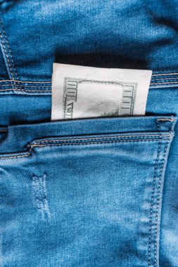 Yırtık ve yıpranmış cebinde Amerikan doları olan eski kot pantolonlar.