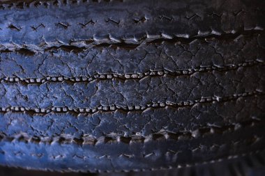 Birkaç eski lastiğin deseni karanlık ve kirli bir odaya istiflenmiş ve terk edilmiş.